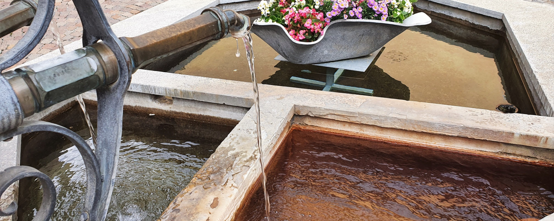 Mineralwasser der Sotsass-Quelle am Dorfbrunnen Bagnera