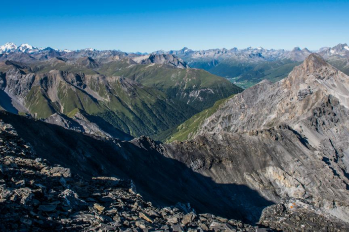 Vue depuis le Piz Quattervals vers le sud. À droite, le Piz d’Esan, au centre la Val Trupchun et au fond les villages de Madulain et La Punt dans l’Engadine supérieure.