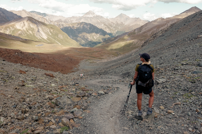 Wanderin mit Rucksack auf Bergwanderung im Engadin, Schweiz – alpiner Wanderweg und Panorama der Schweizer Alpen im Sommer