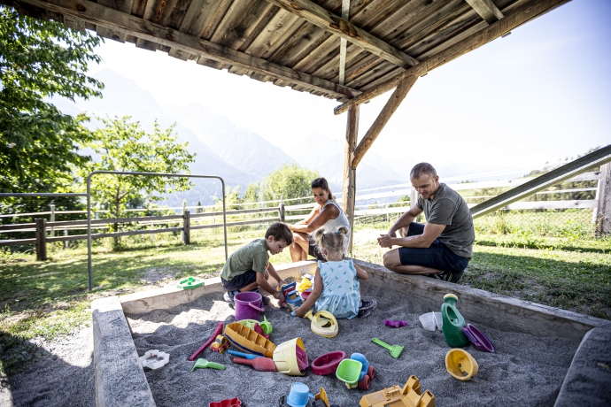 Familie auf dem Spielplatz in Sent