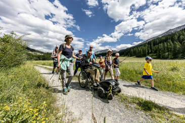 Familie mit Rollstuhlfahrer spaziert im Val Müstair